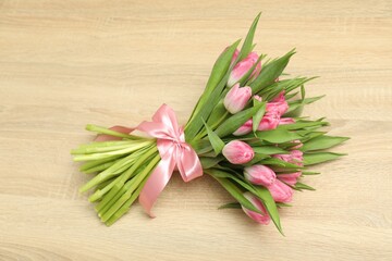 Fototapeta premium Bouquet of beautiful tulips on wooden table, above view