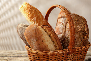 Different loaves of fresh bread in basket on table, closeup