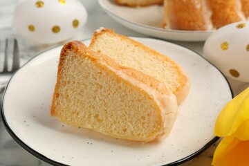 Pieces of delicious bundt cake and Easter eggs on table, closeup