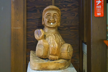 Osaka, japan - Sep 22 2024, Close up view of a wooden idol with the face of a smiling old man, from...