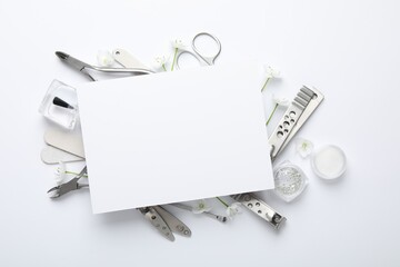 Set of different manicure tools and blank card on white background, flat lay. Space for text