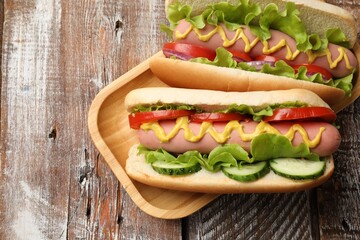 Tasty hot dogs on wooden table, top view