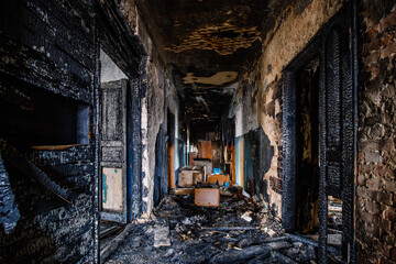 Fire aftermath, burnt room of apartment building, charred walls in black soot