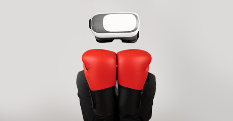 A user engages with virtual reality technology using a headset while wearing red boxing gloves. The...