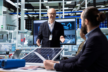 Photovoltaics factory senior manager taking feedback from engineers on upgrades to make to improve...