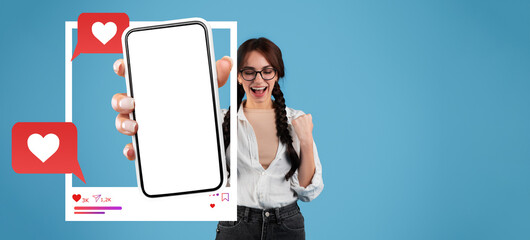 A digital influencer shows excitement by holding a smartphone. The screen displays a blank app,...