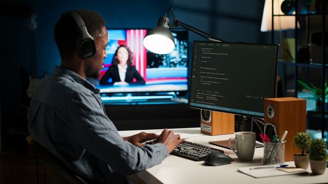 African american male programmer working on cloud computing with an algorithm, writing code for optimization on terminal window. IT specialist inserts html code, server security. Camera B. - Powered by Adobe