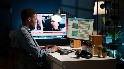 Operating from home setup, male freelancer evaluating monetary data and searching international...
