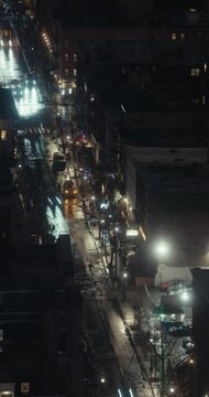 New York City streets, buildings, and traffic during a rainy winter night