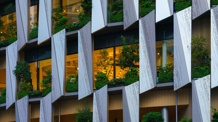 Osaka, Japan - Sep 25 2024, A close-up view of the facade of a modern Hanshin Department Store skyscraper, with hydrangea and trees growing on windows, without people, at daytime, Osaka, Japan