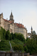 Majestic Sigmaringen Castle Perched on Rugged Cliff Above Tranquil Danube: Historic Hohenzollern Residence Showcases Medieval Architecture in Picturesque Baden-Wurttemberg Landscape
