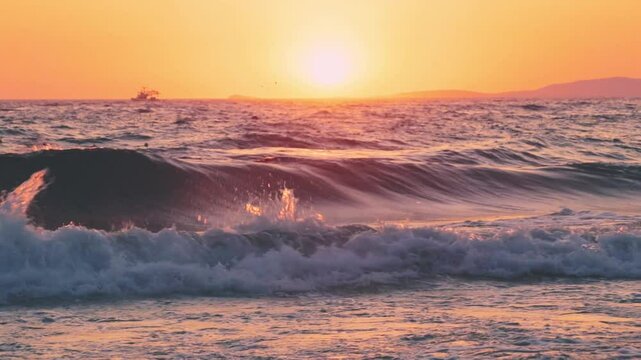 Powerful ocean wave crashes near the shore under a vivid sunset sky, with a distant ship silhouetted on the horizon