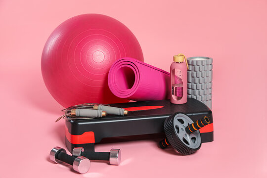Many different fitness equipment on pink background