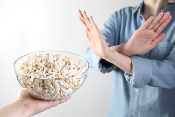 Woman refusing popcorn on white background, , selective focus. Food allergy concept