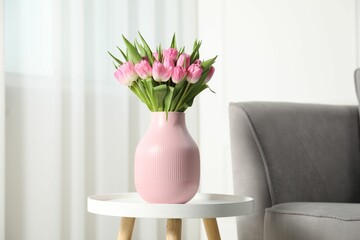 Bouquet of beautiful tulips in vase on white table indoors