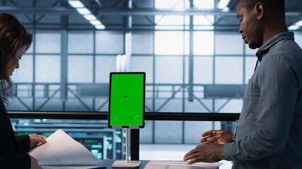Inspector checking documents in server hub to ensure compliance with industry standards, using...