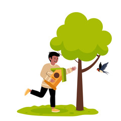 Child smiling while placing a birdhouse next to a tree in a sunny garden setting