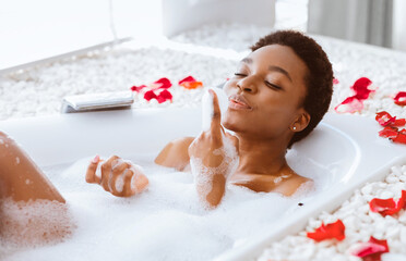 Tropical flowers, organic skin care, spa and healthy lifestyle. Happy young african american pretty...