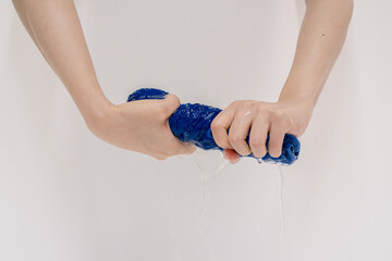 Close-up of Hands Wringing Out a Wet Sponge