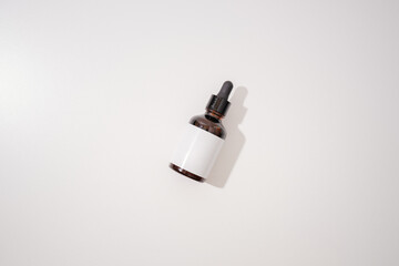 Brown dropper bottle with blank white label on a white background