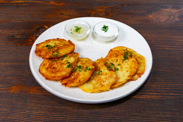 Delicious potato pancakes served with creamy dips on a rustic plate