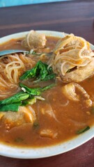 A close up view of a bowl of savory noodle soup