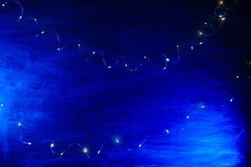 Blue Background with Twinkling Lights.Christmas Shining texture. lights of garlands on a blue background.Background with Fairy Lights.Golden lights of garlands