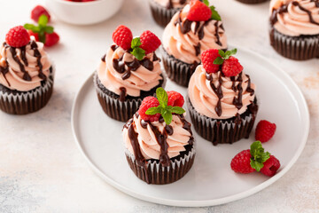 Raspberry chocolate cupcakes with raspberry buttercream frosting a drizzle of chocolate glaze