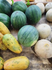 An assortment of various fresh melons and papayas on display