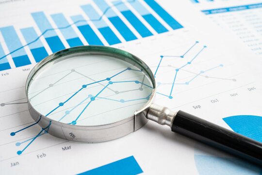 Magnifying glass on charts graphs paper. Financial development, Banking Account, Statistic, Investment Analytic research data economy. - Powered by Adobe