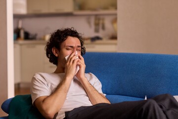 Obraz premium A Young Man Experiencing Discomfort While Enjoying a Relaxing Day at Home Comfortably
