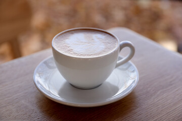 Cup of aromatic coffee on wooden table in cafe, closeup