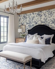 Elegant bedroom with blue floral wallpaper, navy bed, and chandelier.