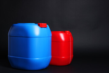 Two plastic canisters on black background, space for text