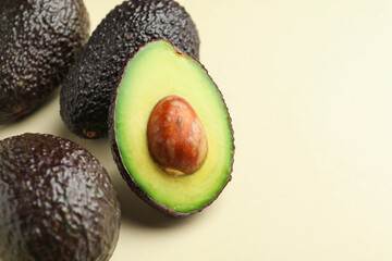 Fresh ripe avocados on beige background, closeup. Space for text