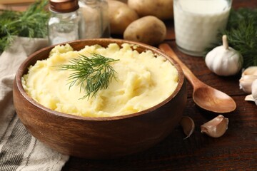 Delicious mashed potato with dill served on wooden table, closeup