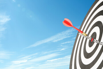 Dart board with arrow against blue sky. Concepts of targeting, decision and goal achievement