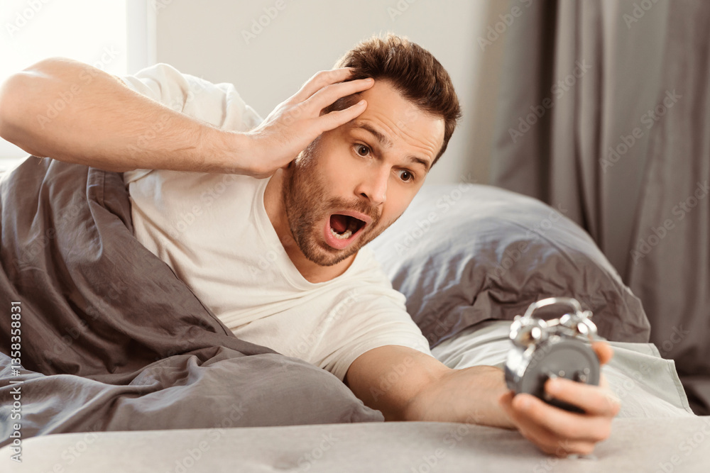Poster overslept man holding alarm clock waking up too late for work lying in bed at home. oversleeping con