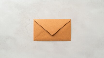 A simple brown envelope on a light gray surface, symbolizing communication or mailing.