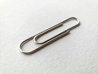 Silver Paper Clip on White Paper