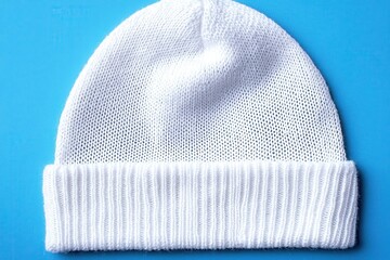 Pristine White Knit Beanie with Subtle Textured Pattern Set Against a Soft Muted Blue Background for Fashion Styling and Accessories