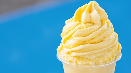 Close-Up of Luscious Golden Butterscotch Pudding Swirls with Whipped Cream in Clear Cup Against Soft Blurred Blue Background