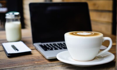 Latte with Laptop on Wooden Table in a Cafe