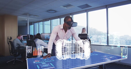 Using VR headset, engineer interacting with holographic interface in modern office