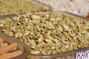 Cardamom pods displayed at a market stand in vibrant colors
