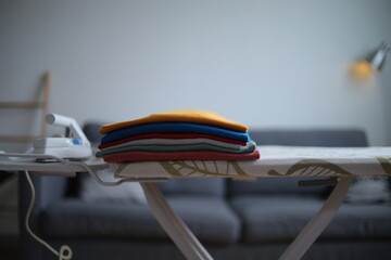 Selective Focus Of Folded Colorful Clothes On Ironing Board At Home