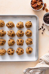 Chocolate chip cookies with pecan nuts, cookie dough ready on a baking sheet