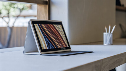 Sleek portable monitor on minimalist desk displaying vibrant abstract design, modern workspace technology and digital creativity concept.