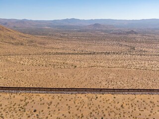 Aerial view of the US-Mexico border fence cutting through the arid desert landscape. The fence...