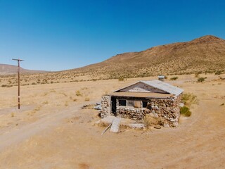 An abandoned stone house sits in the arid landscape of Jacumba, California, USA. The structure,...